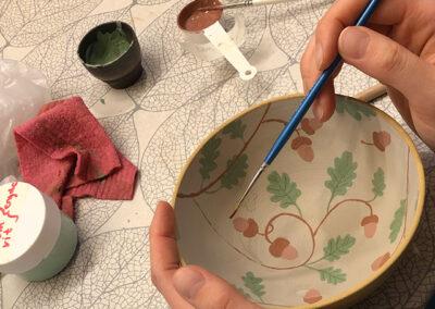 person som målar på keramik